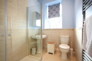 a bathroom with a toilet and a sink and a shower at Ty y Mor in Seahouses +19 photos