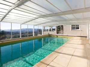 an indoor swimming pool with an open ceiling and windows at Les chambres d'hôtes de Mougins in Mougins