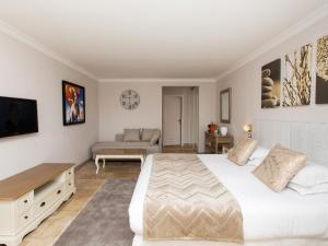 una camera con un grande letto bianco e un divano di Les chambres d'hôtes de Mougins a Mougins