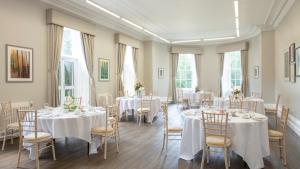 a room with tables and chairs with white tablecloths at Eastwood Hall in Eastwood