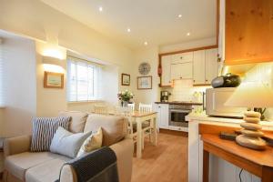 a living room with a couch and a kitchen at Spinnaker in Embleton