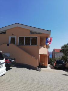 une maison avec un garage avec des voitures garées devant elle dans l'établissement Apartmani Ivanković, à Karlobag