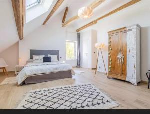 Palleau的住宿－La bergerie et Les Blés Dorés，一间卧室配有一张大床和一个木制橱柜