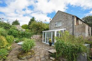 a stone house with a garden in front of it at Stonecrop Cottage in Alwinton