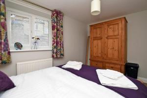 Un dormitorio con una cama grande y una ventana en Schooner Court No2, en Alnmouth