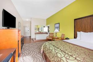 a hotel room with a bed and a flat screen tv at La Quinta by Wyndham Corpus Christi Airport in Corpus Christi