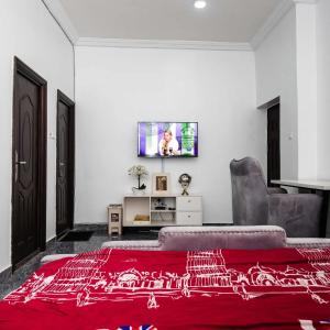 een woonkamer met een rood tapijt en een bank bij Ebrina Apartments in Port Harcourt