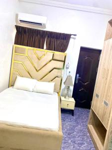 a hotel room with a bed and a window at Ebrina Apartments in Port Harcourt