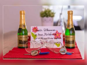 two bottles of champagne and glasses on a table at Fewo Müritzfrische 1 in Waren