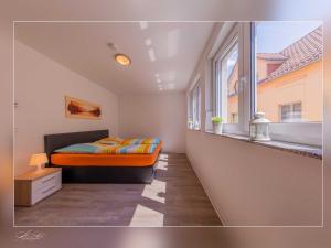 a bedroom with an orange bed and a window at Fewo Müritzfrische 1 in Waren