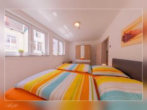 a bedroom with two beds with striped sheets at Fewo Müritzfrische 1 in Waren