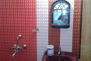 a bathroom with a urinal and a mirror and a sink at Mayelle Agonda in Agonda +1 photo