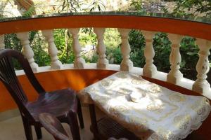 a chair sitting on a balcony with a table and a bowl at Mayelle Agonda in Agonda