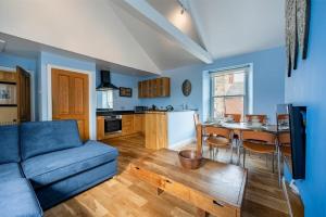 uma sala de estar com um sofá azul e uma mesa em Pilots Rest em Alnmouth
