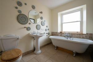 a bathroom with a tub and a sink and a mirror at Pilots Rest in Alnmouth