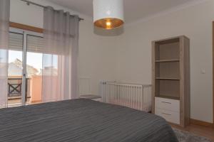 - une chambre avec un lit et une grande fenêtre dans l'établissement Luxe villa Sesimbra secret corner 2, à Sesimbra