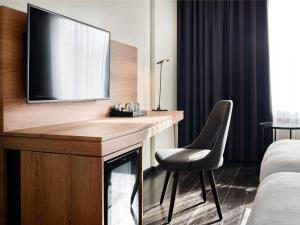 a hotel room with a desk with a television on it at Park Inn by Radisson Luxembourg City in Luxembourg