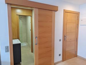 baño con puerta de madera en una habitación en Precioso loft al lado Parc Vallparadís by Lofties, en Terrassa