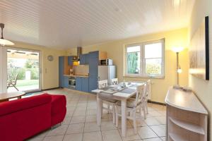 eine Küche und ein Wohnzimmer mit einem Tisch und einem roten Sofa in der Unterkunft FH Wendorff in Klink