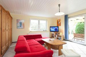 ein Wohnzimmer mit einem roten Sofa und einem Tisch in der Unterkunft FH Wendorff in Klink