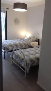 ein Schlafzimmer mit einem Bett in einem Zimmer mit einer Lampe in der Unterkunft Villa au sein d'un élevage de Chevaux in Brucquedal