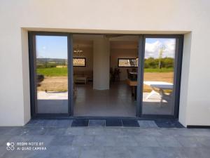 an open glass door of a building with a patio at Villa au sein d'un élevage de Chevaux in Brucquedal