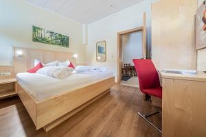 a hotel room with a bed and a red chair at Appartementhaus im Winkel in Sölden