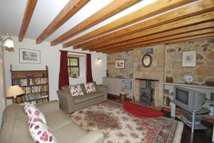 a living room with a couch and a fireplace at The Old School House in Alwinton