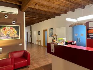 a lobby with a red chair and a counter at Domus San Bernardino in Verona