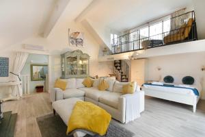 a living room with a white couch and a staircase at The Snug in Embleton