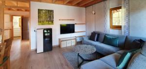a living room with a couch and a tv at Ferienhaus Happyplace in Illach