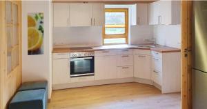 a kitchen with white cabinets and a sink and a stove at Ferienhaus Happyplace in Illach