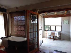 uma casa de banho com uma banheira e uma mesa num quarto em DeKotzenhof em Wakkerstroom