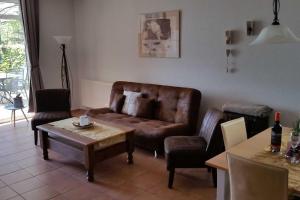 sala de estar con sofá de cuero y mesa en Haus am Kölpinsee App 1 4 en Kölpinsee
