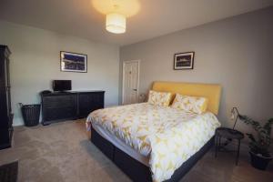 a bedroom with a bed and a dresser and a television at Beachy Head Apartment By Air Premier in Seaford