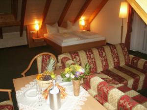 a room with a couch and a table and a bed at Landhotel Rittersgrün in Breitenbrunn