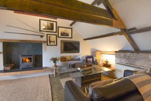 a living room with a couch and a fireplace at Rafters in Alnmouth