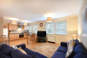 salon z niebieską kanapą i kuchnią w obiekcie Beachcomber Apartment w mieście Bamburgh