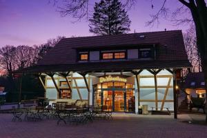 ein Gebäude mit Tischen und Stühlen davor in der Unterkunft Ferienwohnung 6 - Gourmetzimmer in Bestensee