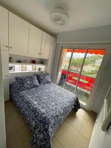 a small bedroom with a bed and a window at Charmant 2 Pièces Vue sur Mer et MONTE-CARLO à ROQUEBRUNE CAP MARTIN in Roquebrune-Cap-Martin