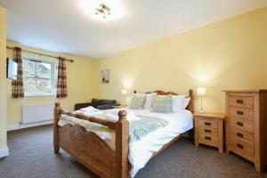 a bedroom with a large bed and a dresser at Greenfinch in Lucker