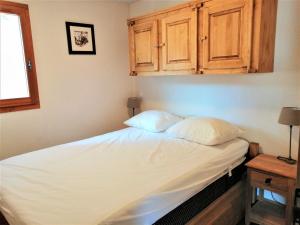 a bed in a room with wooden cabinets at Appartement Morillon 1100, 3 pièces, 6 personnes - FR-1-412-55 in Morillon