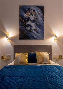 a bedroom with a blue bed with a painting above it at Apartamenty Yeti & Wilka w Centrum Chorzowa - Yeti in Chorzów
