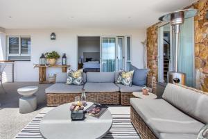 sala de estar con sofá y mesa en Far Horizons Camps Bay en Ciudad del Cabo