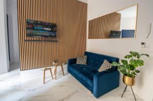 a living room with a blue couch and a potted plant at Apartamenty Yeti & Wilka w Centrum Chorzowa - Yeti in Chorzów