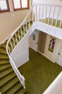 eine Wendeltreppe in einem Haus mit grünem Teppich in der Unterkunft Kloster Bonlanden in Berkheim