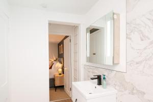 ロイヤル・タンブリッジ・ウェルズにあるStunning 2-bedroom home in city centre with Wi-Fi!の白いバスルーム(シンク、鏡付)