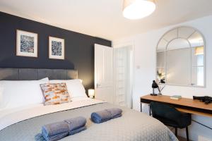 a bedroom with a large bed and a desk at Stunning 2-bedroom home in city centre with Wi-Fi! in Royal Tunbridge Wells
