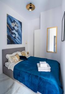 a bedroom with a bed with a blue blanket at Apartamenty Yeti & Wilka w Centrum Chorzowa - Yeti in Chorzów