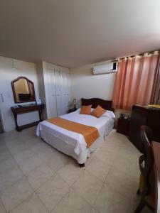 a bedroom with a large bed and a mirror at Hotel Khalifa in Neiva